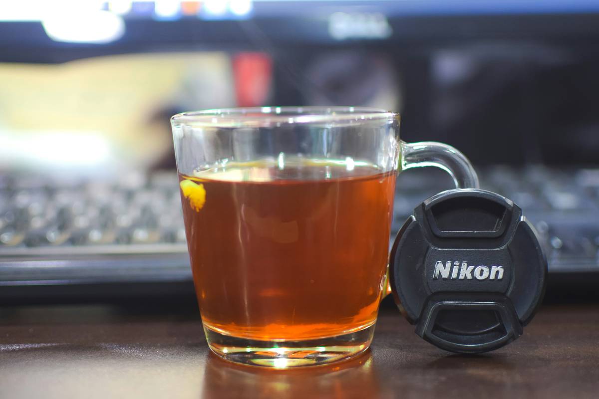 a glass of tea next to a computer keyboard