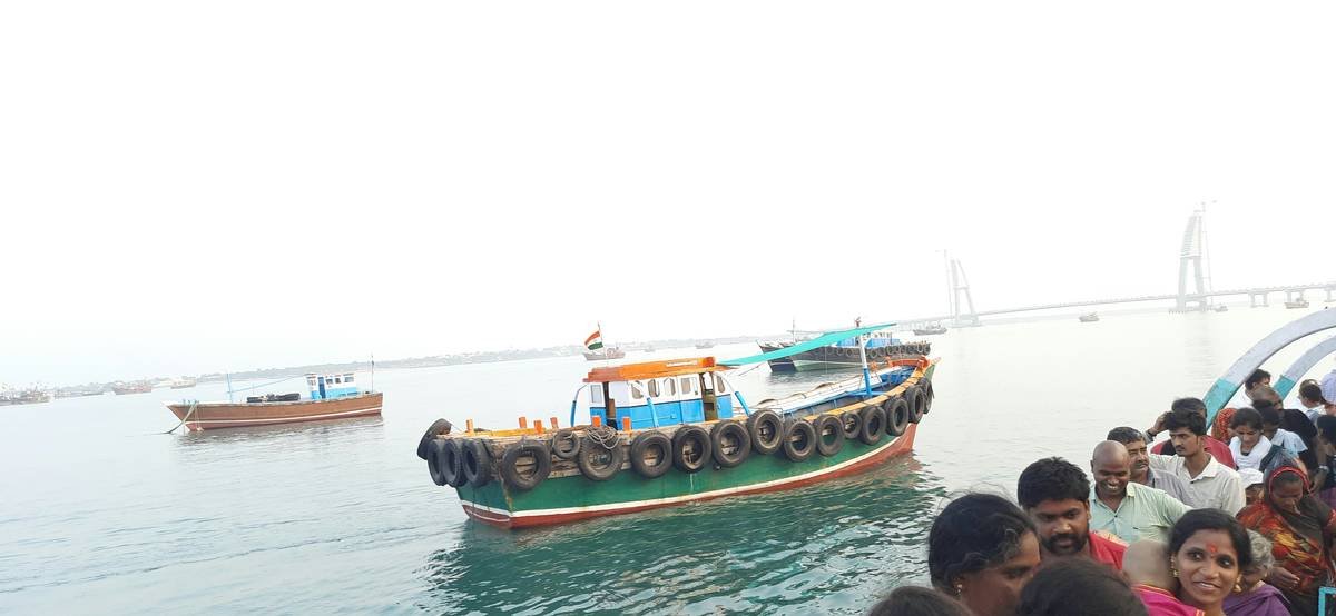 a group of people standing next to a boat in the water