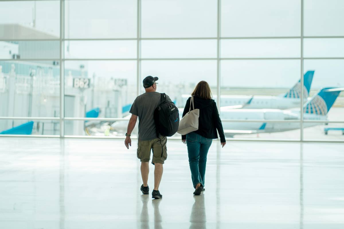 a man and a woman walking through an airport