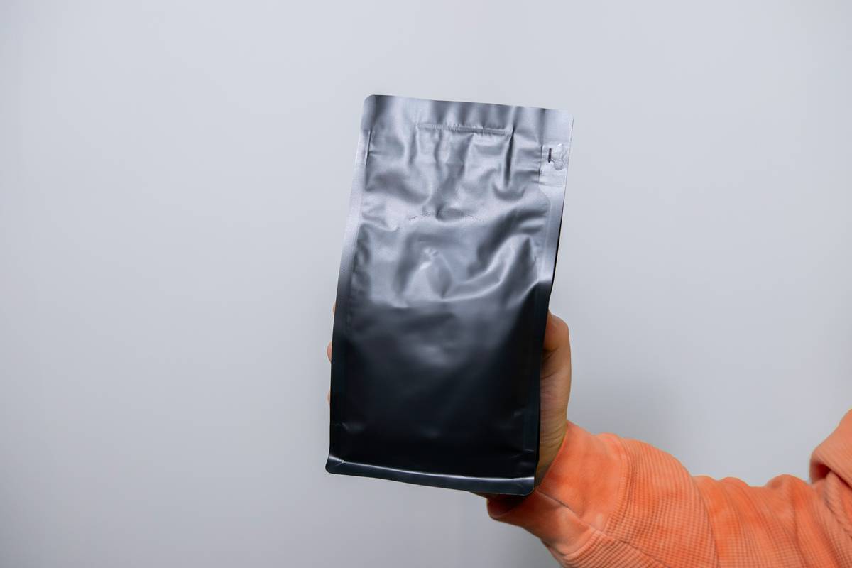a person holding a bag of coffee in their hand