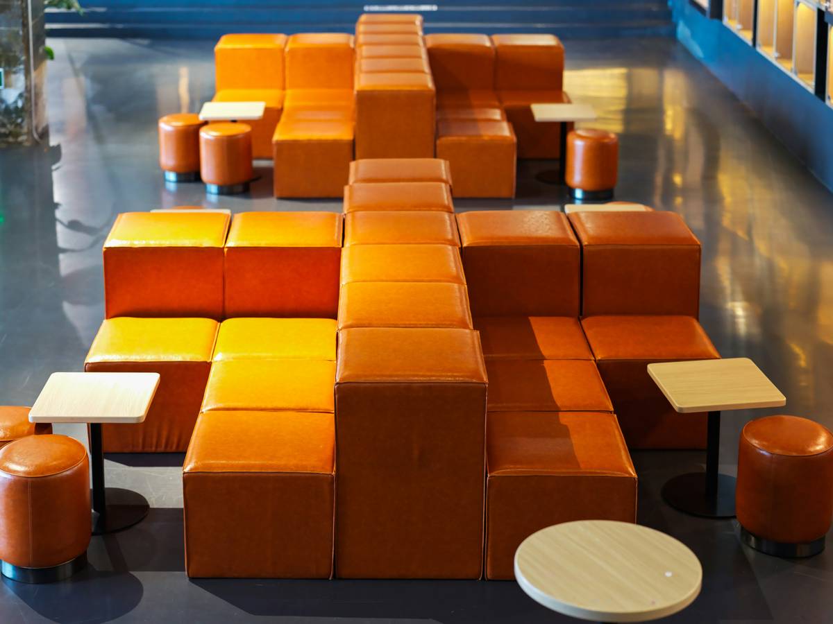 A room filled with lots of orange couches and tables