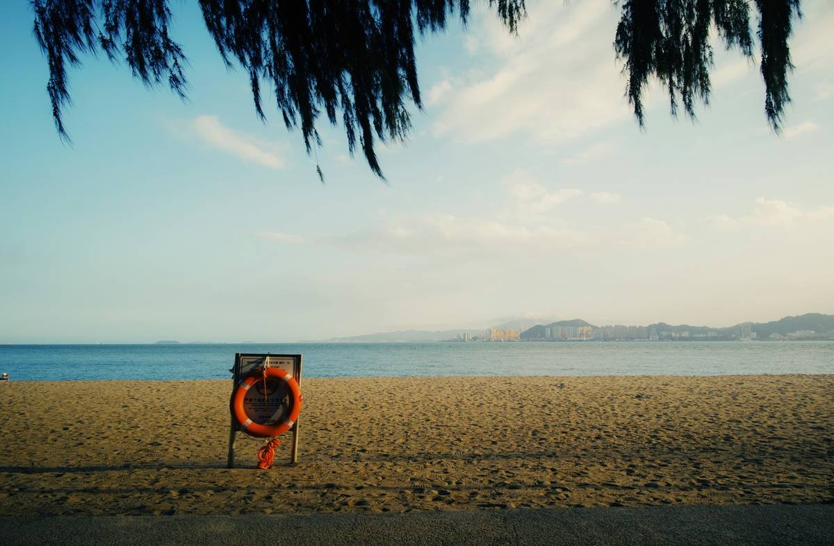 Beach with life preserver and distant mountains
