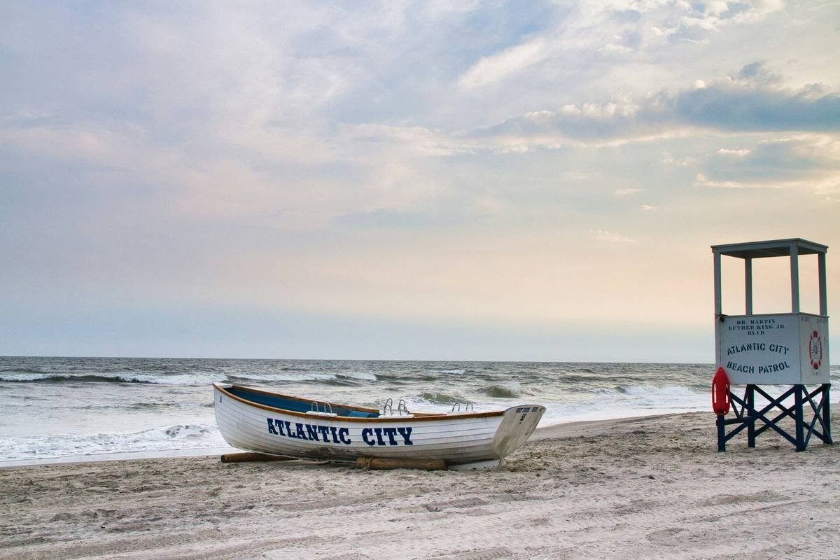 Boat and lifeguard stand on a sandy beach.