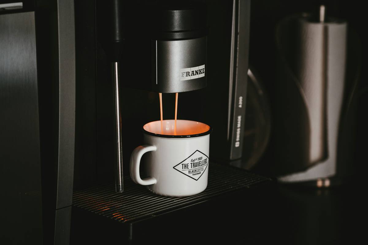 Coffee running from a FRANKE machine into a coffee mug